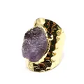 Close-up of a wide gold hammered ring featuring a raw purple amethyst stone detail. - Amethyst