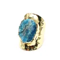 Close-up detail of wide hammered gold ring with a large blue raw crystal stone - Apatite
