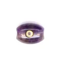 Close-up macro detail of a purple amethyst barrel bead with a gold-bezel zircon inlay - Amethyst