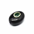 Close-up of black natural stone barrel bead with inlaid green zircon for DIY jewelry - Barrel Beads / Obsidian