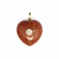 Vue détaillée d'un pendentif en forme de cœur en grès doré avec zircon central serti - Pierre de Sable d'Or