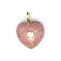 Gros plan d'un pendentif cœur en pierre naturelle rose avec zircon et bélière dorée. - Rhodonite