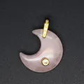 Macro close-up of a pink rose quartz crescent moon pendant with gold cubic zirconia inlay - Rose Quartz