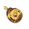 Detailed macro shot of a carved tiger eye stone ammonite pendant with a small center zircon - Tiger's Eye