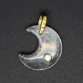 Detailed macro shot of a crescent moon shaped natural stone pendant with gold zircon bail - White Crystal