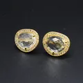 High-quality close-up of baroque style irregular faceted crystal stud earrings in gold - White Crystal