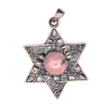 Gros plan d'un pendentif Étoile de David en bronze vintage avec une pierre de Picasso rose - Rhodonite