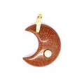 Macro detail of a brown goldstone moon pendant featuring a sparkling zircon inlay. - Gold Sandstone