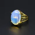 Vista dettagliata di un elegante anello placcato oro 24k con una grande gemma ovale. - Opale