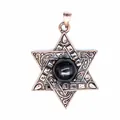 Gros plan d'un pendentif hexagramme vintage avec des motifs et une pierre noire. - Obsidienne
