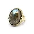 Macro detail of a vintage-style gold ring featuring a large faceted oval labradorite stone. - Labradorite