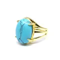 Dettaglio di un anello placcato in oro con una grande pietra ovale turchese - Turchese blu