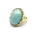 Close-up macro view of a faceted oval green amazonite gemstone set in a gold carved ring - Amazonite