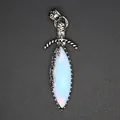 Detailed macro view of a vintage silver sword pendant set with a luminous opal stone - Opal