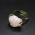 Detail of a raw pink rose quartz crystal ring with a golden adjustable claw setting - Rose Quartz