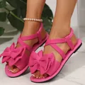 Elegante rosa flache Sandalen mit großer Schleife und elastischem Kreuzriemen für Damen. - Fuchsia