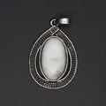 Detailed macro shot of an antique silver teardrop pendant with a white marbled oval stone - Howlite