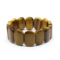 Close-up detail of natural tiger eye stone bracelet featuring smooth polished oval beads. - Hand Plate Style / 11x18mm / Yellow Tiger Eye