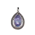 Macro detail of a vintage oval purple stone teardrop pendant in a carved silver setting - Fluorite