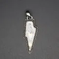 Macro detail of a vintage lightning bolt pendant featuring a natural white crystal stone. - White Crystal