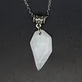 Macro detail of a faceted semi-transparent natural stone pendant on a silver-tone chain - White Crystal
