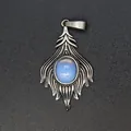 Macro view of vintage silver fox tail pendant featuring a central oval light blue stone - Opal