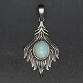Detailed close-up of a vintage fox tail pendant with a light blue natural stone inlay - Aquamarine