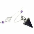 Macro view of blue sandstone pyramid crystal pendulum featuring a silver pentagram charm. - Blue Sandstone