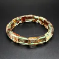 Macro view of natural phantom quartz crystal bracelet with unique inclusions - Green Ghost Quartz