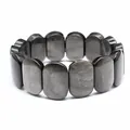 Detailed close-up showing the polished surface of dark oval natural stone bracelet - Hand Plate Style / 11x18mm / Silver Obsidian