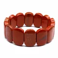 Macro view of a natural red jasper bracelet featuring polished 11x18mm oval beads - Hand Plate Style / 11x18mm / Red Jasper