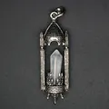 Macro detail of a vintage medieval castle pendant featuring a natural hexagonal crystal. - White Crystal / Antique Silver