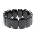 Close-up detail of smooth polished black oval natural stone beads on a stretch bracelet - Hand Plate Style / 11x18mm / Obsidian