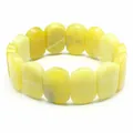 Macro detail of polished yellow oval natural stone beads on a minimalist stretch bracelet - Hand Plate Style / 11x18mm / Citrine
