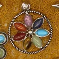 Close-up detail of a silver flower pendant set with seven colorful marquise gemstones - Round Flower Style (1)
