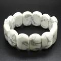 Macro view of polished white howlite oval beads on an elastic natural stone bracelet - Hand Plate Style / 11x18mm / White Turquoise