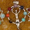 Close-up of a silver chakra pendant with colorful gemstones and human figure design. - Human Figure Outline Style (24)
