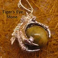Detailed silver-tone dragon claw pendant holding a polished round tiger eye gemstone bead - Dragon Claw Grip (aljylp0065) / Tiger's Eye Pendant