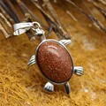 Exquisito colgante con forma de tortuga con piedra de oro marrón brillante y acabado plateado - Piedra de Arena Dorada
