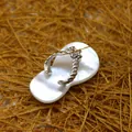 Elegant flip-flop shell pendant with white mother-of-pearl and silver bow detail. - White Shell