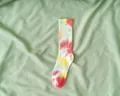 Vivace calzino tie-dye multicolore esposto con stile su un morbido tessuto verde - Taglia unica / Rosso Floreale