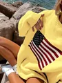 Close-up view of a yellow oversized knitted sweater featuring a retro American flag pattern - Yellow