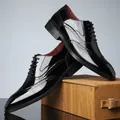 Dettaglio di scarpe brogue da uomo in pelle verniciata nera con motivi intagliati - 39 / Nero