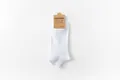 White low cut cotton athletic socks featured with a minimalist brown paper card packaging - One Size / Men's Boat Socks / White