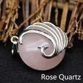 Rose quartz peacock pendant with silver metal wings on a natural wood background - Rose Quartz