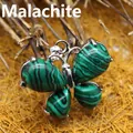Butterfly pendant with malachite green stone in a natural twig background setting - Malachite