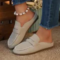Close-up of beige suede backless loafers on a lifestyle setting with denim jeans - 36 / Off White