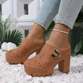Close-up detail of stylish tan platform mules with laser-cut floral pattern and buckle - Tan