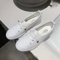 Detailed top view of minimalist white leather board sneakers with decorative laces for women - 35 / White