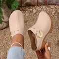 Detail view of beige patent leather clogs featuring chunky high heels and gold studs. - 35 / Apricot